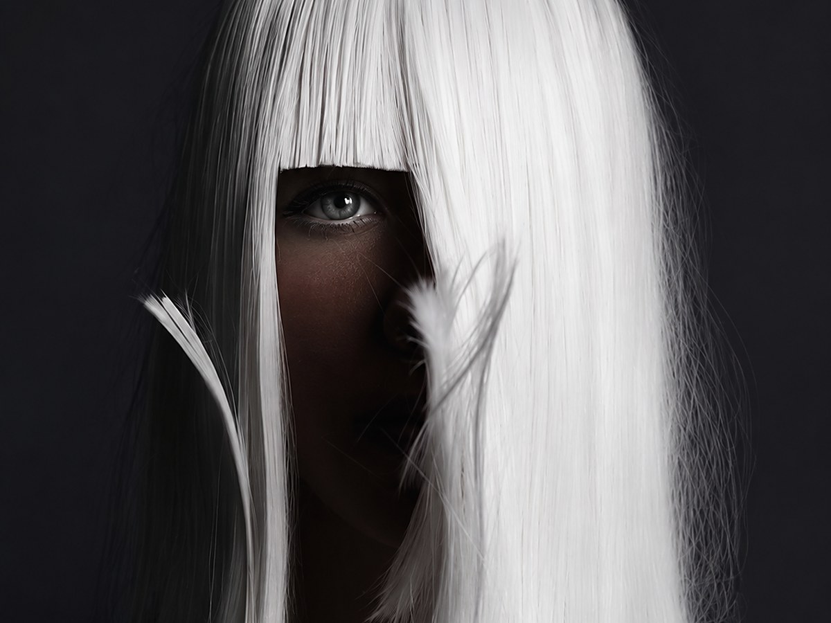 Long silver-white hair falling across the face — editorial portrait
